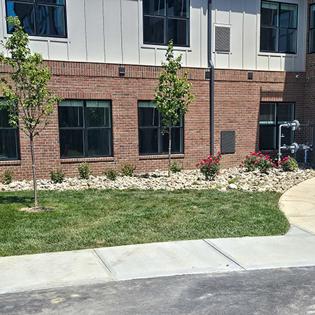 The exterior at Holliday Farms, featuring landscaped beds.